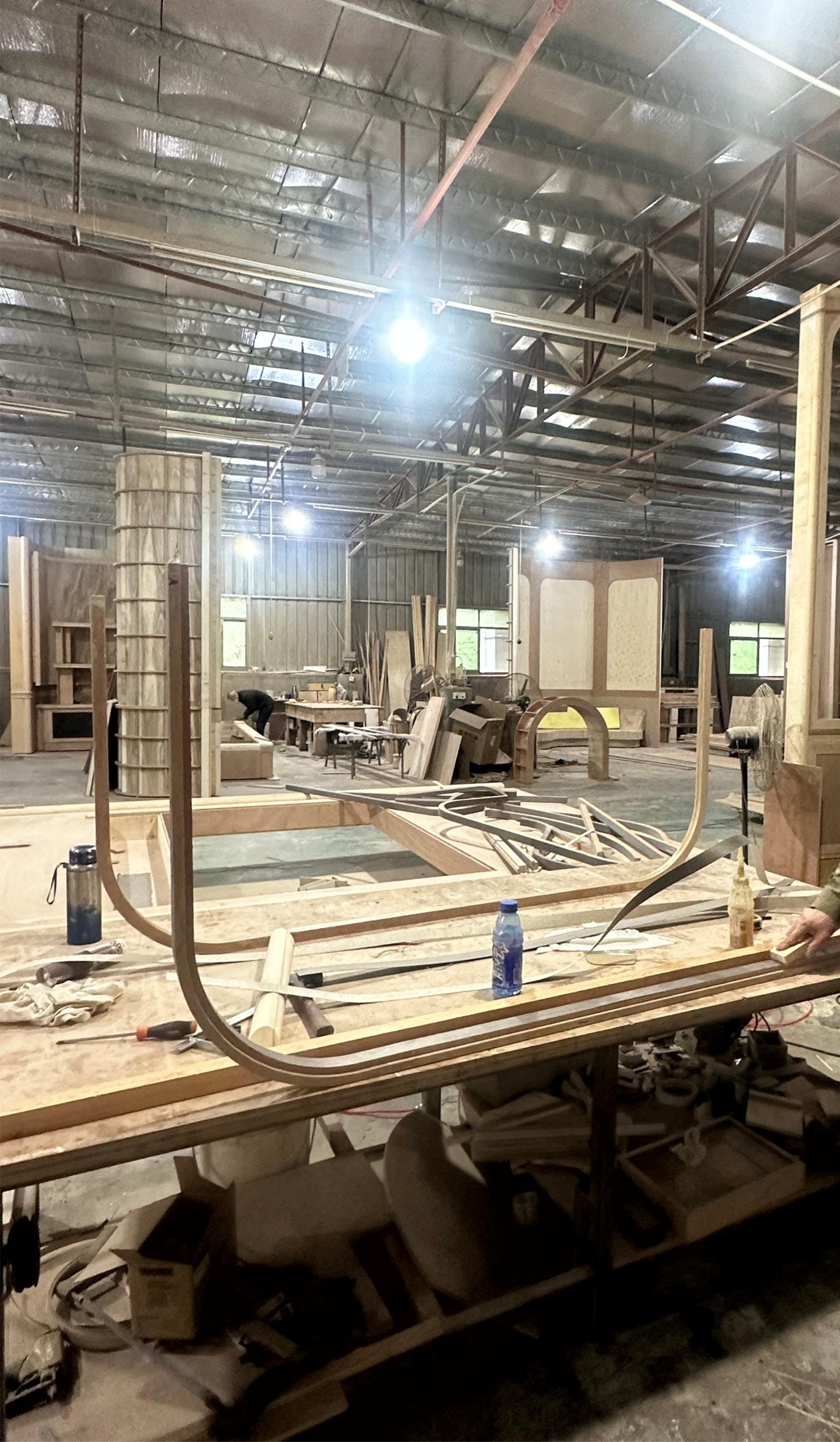 Workshop interior showing curved timber bending jigs in production